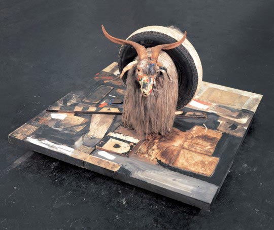 Hugo Brissaud, Robert Rauschenberg, Monogram, 1955-1959. Huile, papier imprimé, reproductions imprimées, métal, bois, talon en caoutchouc et balle de tennis sur toile, avec huile sur chèvre angora et pneu sur socle en bois monté sur quatre roulettes, 106,6 x 160,6 x 163,8 cm. Moderna Museet, Stockholm.