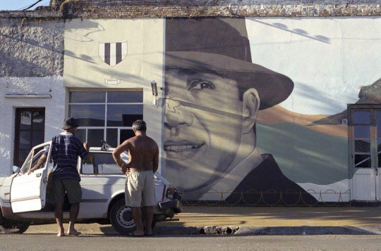 Martin Barzilai, Deux hommes devant une peinture representant le chanteur de tango, Carlos Gardel considere comme faisant partie du patrimoine national. San Gregorio de Polanco. Uruguay. Mars 2006, Martin Barzilai/Sub.Coop